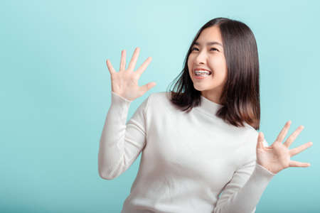 Dental braces of young asian woman wearing braces beauty smile with white teeth increase confidence for healthy on blue background isolated studio shot, Shocked and Glad promotion with copy space.の写真素材