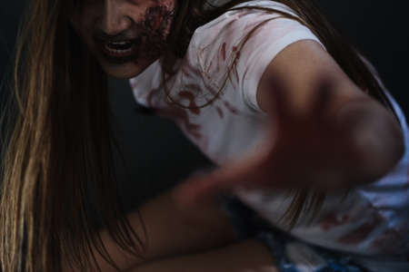 Zombie characters ghost woman bite human in wall horror halloween at nightmare, Female evil screaming monster in night background infected with bleed movie scene film in holiday festival concept.の写真素材