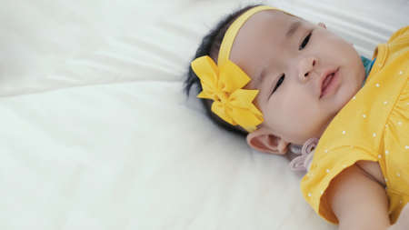 Asian mother takecare her cute baby sleeping and kissing on bed at home, happy mother and baby,...