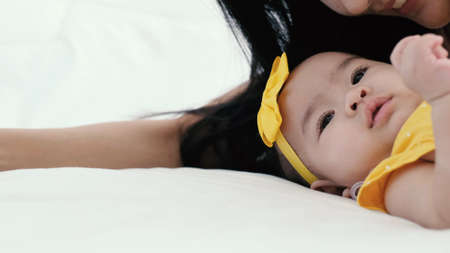 Asian mother takecare her cute baby sleeping and kissing on bed at home, happy mother and baby, Beautiful conceptual image of Maternity health care Happy loving family concept.の写真素材