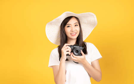 Happy smiling asian young girl photographer wearing hat and hold camera DSLR and photo camera ready...