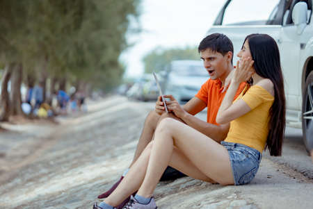 Couple young man and woman using laptop computer for searching information study education outdoor in university or learning online technology concept.の写真素材