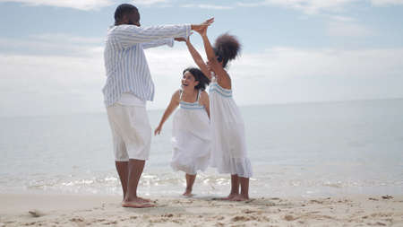 Ethnicity Happy Family Africans Enjoy playing on the beach summer vacation time happiness group people American, Asian outdoors nature.の写真素材