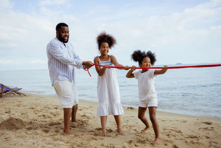 Ethnicity Happy Family Africans Enjoy playing on the beach summer vacation time happiness group people American, Asian outdoors nature.の写真素材