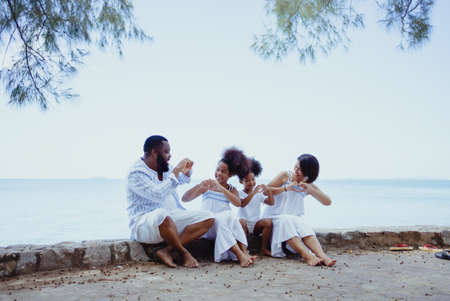 Ethnicity Happy Family Africans Enjoy relaxation resting on the beach summer vacation time happiness group people American, Asian outdoors nature.の写真素材