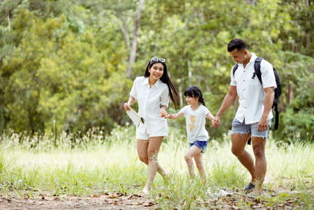 Happy asian family with daughter playing and travel in forest on weekend holidays relaxation adventure together lifestyle.の写真素材