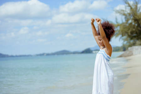 Kid girl american african playing relax enjoy life funny moment on the beach in sea view nature holiday summer time resting concept.の写真素材