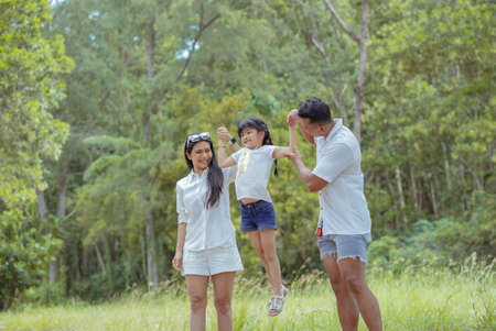 Happy asian family with daughter playing and travel in forest on weekend holidays relaxation adventure together lifestyle.の写真素材