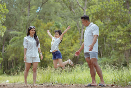 Happy asian family with daughter playing and travel in forest on weekend holidays relaxation adventure together lifestyle.の写真素材