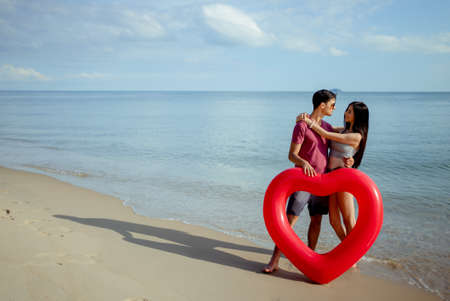 Couple young man and woman dating looking sea on the beach travel happy romantic outdoor enjoying on weekend holidays, Embracing lover together.の写真素材