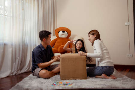 Happy asian family having fun with playing game wooden block at home with mother sit on floor together, family having fun enjoying talking with children.の写真素材