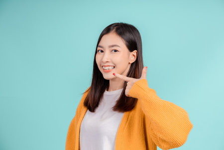 Dental of young asian woman wearing retainer braces glad emotion with white teeth increase confidence for healthy on blue background isolated, Happiness teenager smiling facial expression.の写真素材
