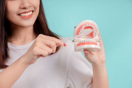 Dental Beautiful smiling of young asian woman teach correct teeth brushing  and toothbrush for white teeth increase confidence for healthy on blue background isolated, Happiness facial expression.の写真素材