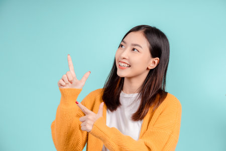 Dental of young asian woman wearing retainer braces glad emotion with white teeth increase confidence for healthy on blue background isolated, Happiness teenager smiling facial expression.の写真素材