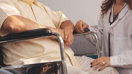 Close up Shot: Female nurse doctor in uniform health check senior grandfather patient at home medical visit, Elderly old male people healthcare support and encouraging the patient in life.の写真素材