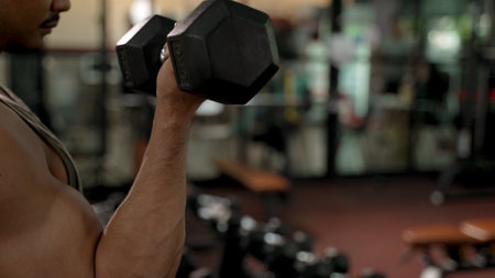 Sport Athlete man Lifting dumbbells Ready Workout in Fitness gym Healthy Lifestyle bicep bodybuilding, Training builder muscles lifestyle concept.の写真素材