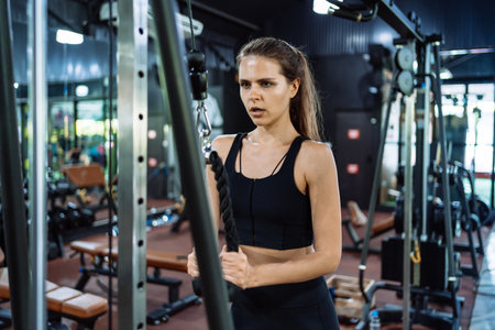 Sport Athlete Woman Workout Weight Training with Cable Machine in Fitness gym Healthy Lifestyle bodybuilding, Active training builder muscles lifestyle.の写真素材