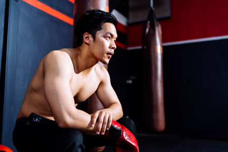 Male Boxer Athlete Rest After Training workout exercise in Fitness Gym Healthy Lifestyle bodybuilding, Athlete punching builder muscles lifestyle, Happy health care mobility concept.の写真素材