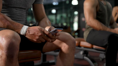 Member in Fitness gym using smartphone technology planing workout, Healthy Lifestyle bodybuilding, Athlete builder muscles lifestyle, Coach training online concept.の写真素材