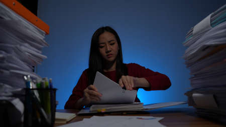 Stressed young asian woman sitting work overtime doing late time business at office in night on desk, Exhausted businesswoman concept.の写真素材
