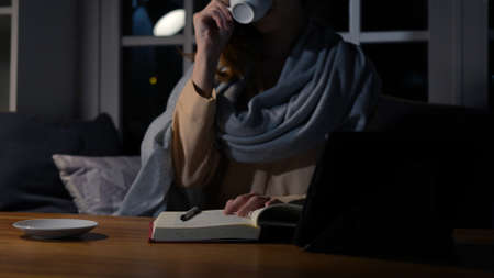 Asian businesswoman or freelancer working hard at the night looking the laptop digital tablet and...