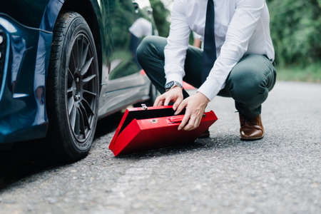 Asian businessman broken car engine breakdown his stressed emotion problem, Accident emergency on the mountain road outdoor late for work concept.の写真素材