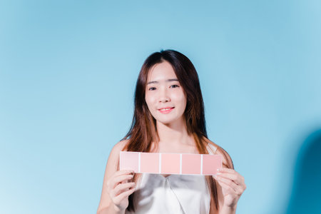 Charming asian beauty woman take color scale on the blue backgroundの写真素材