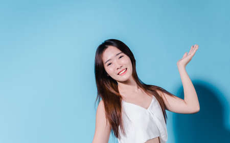 Charming asian beauty woman hold sun cream with sun protection uv or sunscreen on the blue backgroundの写真素材