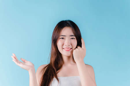 Charming portrait of Asian woman smiling confidence beauty make up on the blue backgroundの写真素材