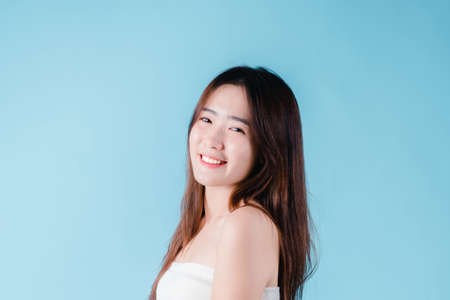 Charming portrait of Asian woman smiling confidence beauty make up on the blue backgroundの写真素材