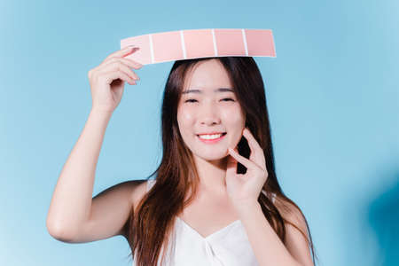 Charming asian beauty woman take color scale on the blue backgroundの写真素材