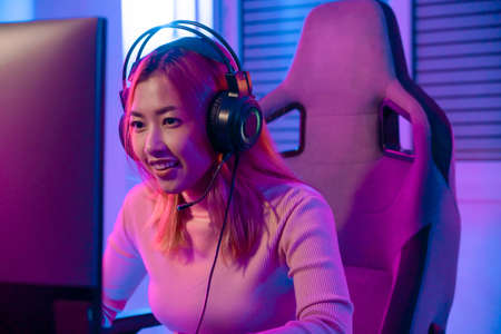 A Professional female pro gamer play online video games cyber sport and esport winner emotion. Young woman in tournament match worldwide in room colorful neon lights.の写真素材
