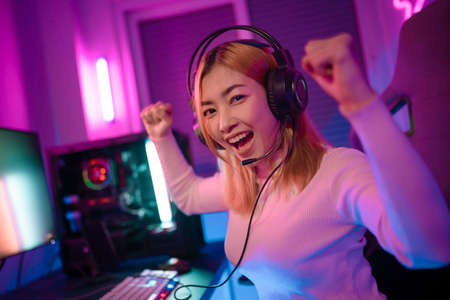 A Professional female pro gamer play online video games cyber sport and esport winner emotion. Young woman in tournament match worldwide in room colorful neon lights.の写真素材