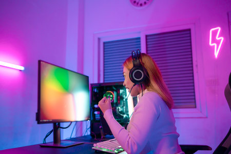Gamer female playing virtual reality games cyber sport and esport. Young woman getting 3D experience with VR in room colorful neon lights.の写真素材
