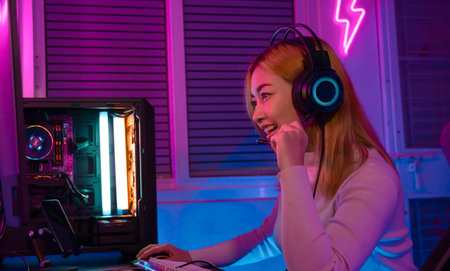 Gamer female playing virtual reality games cyber sport and esport. Young woman getting 3D experience with VR in room colorful neon lights.の写真素材