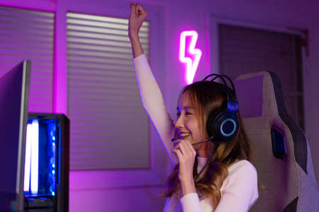 Young people Backache. Gamer and E-Sport online of Asian woman playing online computer video game with lighting effect,の写真素材