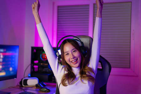 Asian gamer playing online video game winning excited on PC with lighting effect, broadcast streaming live at home. Gamer and E-Sport online gaming technology Championship tournament gamer concept.の写真素材
