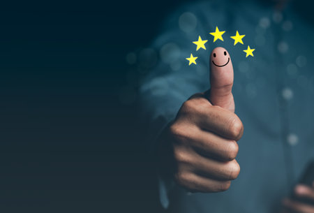Customer satisfaction concept. Hand with thumb up Positive emotion smiley face icon and five starの写真素材