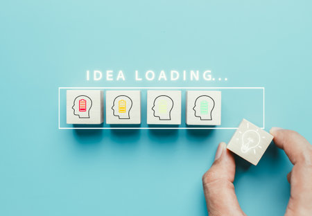 Idea loading concept. Thinking innovation and creativity process and problem solving solution business technology. Hand putting cube block with light bulb icon.の写真素材
