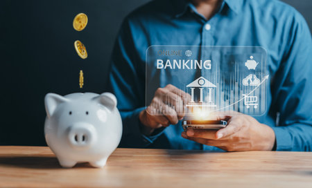 Banking and Savings money, Man using mobile phone app for savings money or investment with online banking application technology. Coin falling to piggy back. retirement planning and insurance concept.の写真素材