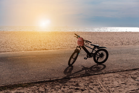 Bicycle with helmet parked on the seaside with sea beach beautiful background.