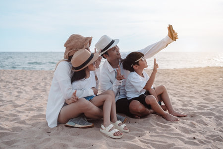 Happy asian family on the beach in holiday. of the family take a selfie.They are having fun playing enjoying on the beach. Summer Family and lifestyle.の写真素材
