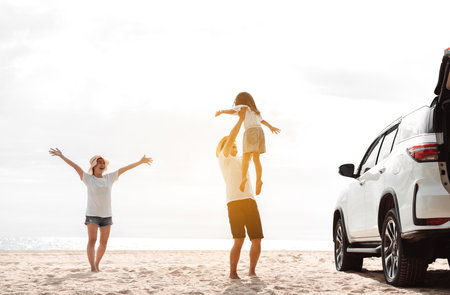 Happy Family with car travel road trip. summer vacation in car in the sunset, Dad, mom and daughter happy traveling enjoy together driving in holidays, people lifestyle ride by automobile.の写真素材