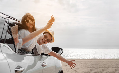 Hatchback Car travel driving road trip of family summer vacation in car at sunset,Girls happy traveling enjoy holidays and relaxation together get the atmosphere and go to destinationの写真素材