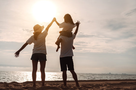 Happy asian family enjoy the sea beach at consisting father, mother and daughter having fun playing beach in summer vacation on the ocean beach. Happy family with vacations time lifestyle concept.の写真素材