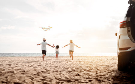 Happy Family with car travel road trip. summer vacation in car in the sunset, Dad, mom and daughter happy traveling enjoy together driving in holidays, people lifestyle ride by automobile.の写真素材