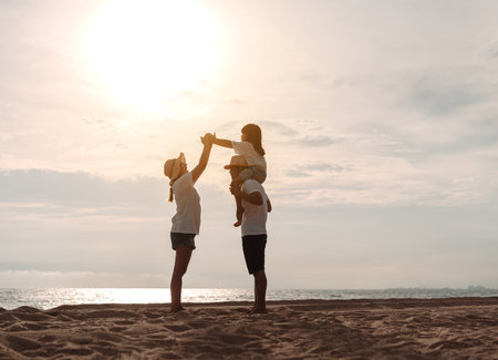 Happy asian family enjoy the sea beach at consisting father, mother and daughter having fun playing beach in summer vacation on the ocean beach. Happy family with vacations time lifestyle concept.の写真素材