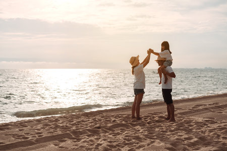 Happy asian family enjoy the sea beach at consisting father, mother and daughter having fun playing beach in summer vacation on the ocean beach. Happy family with vacations time lifestyle concept.の写真素材