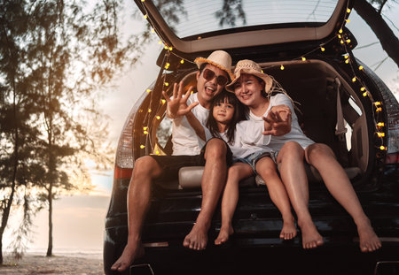 Happy Family with car travel and camping road trip. summer vacation in car in the sunset, Dad, mom and daughter happy traveling enjoy together driving in holidays, people lifestyle ride by automobile.の写真素材