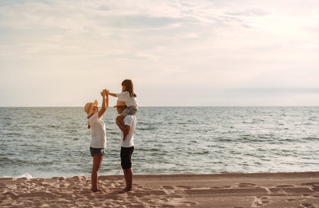 Happy asian family enjoy the sea beach at consisting father, mother and daughter having fun playing beach in summer vacation on the ocean beach. Happy family with vacations time lifestyle concept.の写真素材